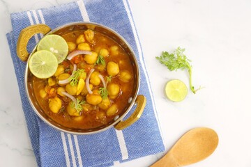 Indian food. Fresh chickpea masala, Chole masala curry, traditional north Indian dish. Popular Amritsari Chole bhature. Chana masala Garnished with lemon and onion. food photography. Copy space.