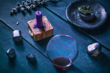 Divination. A magic ball on a table with a candle, crystals, and some herbs for a ritual