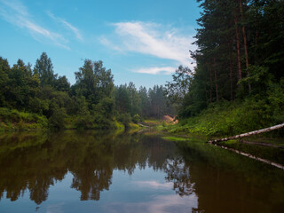 Obraz premium Mirror surface of the river water surface in the middle of the forest. Silence in unique natural locations far from civilisation.