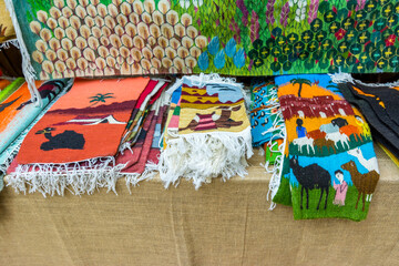 Traditional Arabic scarf and carpet with colorful patterns for sale in the Heritage folk village in Abu Dhabi, United Arab Emirates.