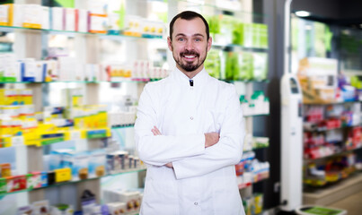 Ordinary pharmacist showing assortment of drugs in pharmacy