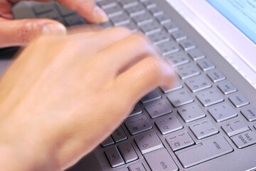 ノートパソコンをタイピングする女性