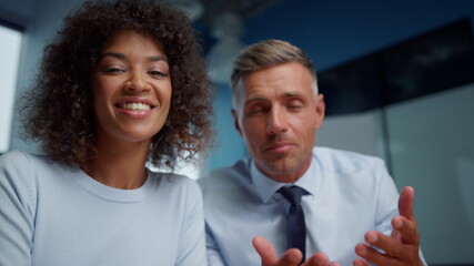 Joyful businessman and businesswoman making video conference online with clients