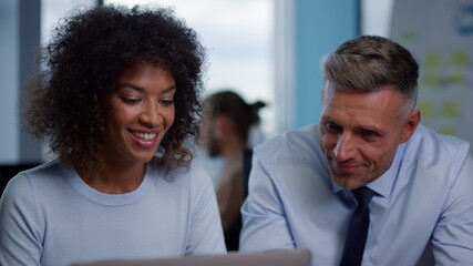 Smiling businesswoman and businessman looking at good work results in office