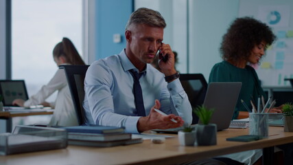 Confident businessman talking on smartphone. Disappointed man using mobile phone