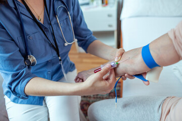 Close up of Nurse Taking Blood Samples from Elderly Patient. Female Caregiver Obtaining Blood...