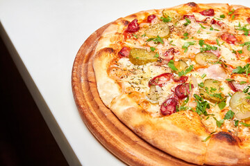 Fresh pizza pickles, bacon, sausages and cheese on a wooden board. Close-up, selective focus