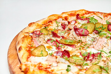 Fresh pizza pickles, bacon, sausages and cheese on a wooden board. Close-up, selective focus