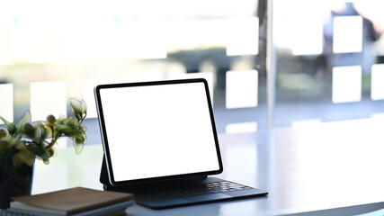 Freelancer workspace with a blank screen computer tablet on white table. Blank screen for products display montage.
