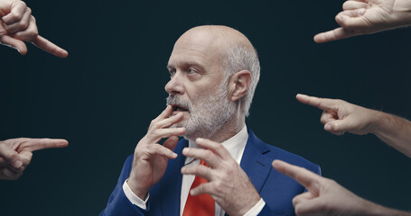 Many fingers pointing at one guilty businessman