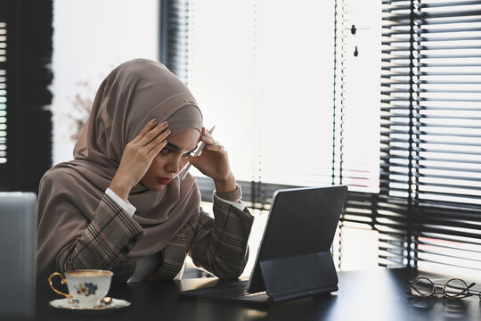 Thoughtful Or Stressful Islamic Woman In Hijab Is Headache And Stresses Have A Trouble And Problem Of Her Work.
