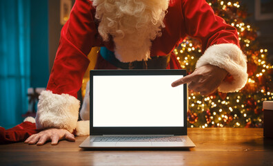 Santa Claus pointing at the laptop screen
