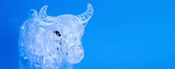 Figurine of a bull from three dimensional puzzles on blue background. Symbol of coming New Year...