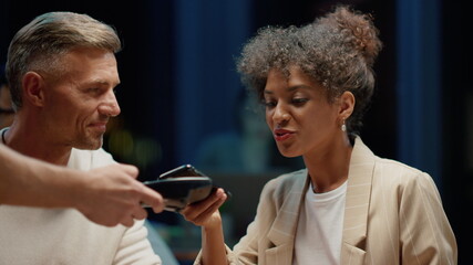 Businesswoman using smartphone for payment in cafe.Business man showing thumb up