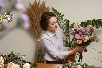 young woman florist in her studio makes a beautiful bouquet. Working moments