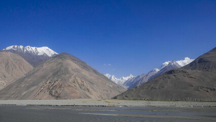 View of the Hindu Kush snow-capped peaks on the Afghan side of the Panj river valley around  Langar village, Wakhan Corridor, in Gorno-Badakshan, the Pamir region of Tajikistan