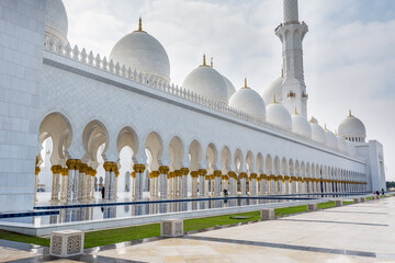 Architectural details of  White Grand Mosque built with marble stone against cloudy sky, also called Sheikh Zayed Grand Mosque in Abu Dhabi, UAE