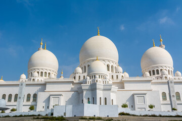 Fototapeta na wymiar Domes of White Grand Mosque built with white marble stone, also called Sheikh Zayed Grand Mosque, inspired by Persian, Mughal and Moorish mosque architecture