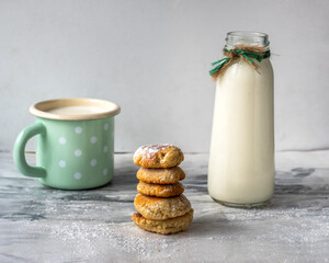 Breakfast with milk in an enamel green mug with butterflies and homemade cookies o