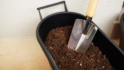 プランターに腐葉土をスコップでいれる
