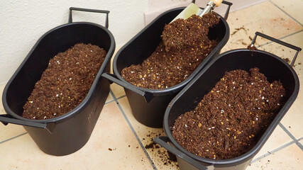 プランターに腐葉土をスコップでいれる