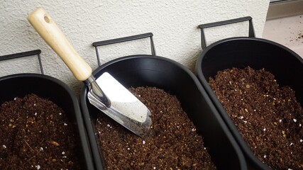 プランターに腐葉土をスコップでいれる