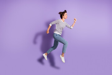 Fototapeta na wymiar Full length photo of lovely slim lady dressed casual clothes jumping running isolated purple color background