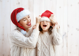 Fototapeta premium girl and her mother in Santa's hats
