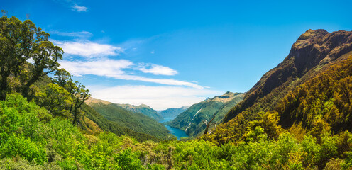 Spectacular panorama at Doubtful Sound View Point looking down to the remote fjord from the top of the mountain on a beautiful day in summer, in New Zealand, South Island.