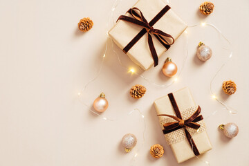 Modern Christmas composition. Gift boxes, balls, garland on pastel beige background. Minimal, Scandinavian style. Flat lay.