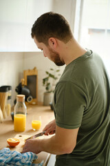 Fototapeta na wymiar Young handsome man cooking healthy breakfast in the kitchen