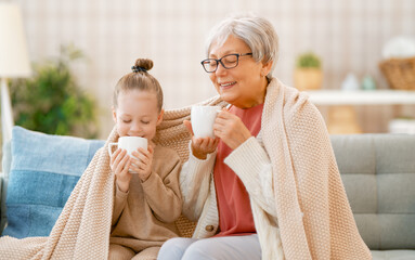 girl and her grandmother enjoying warm beverages