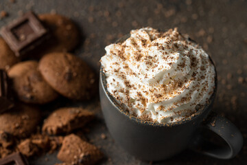 Hot chocolate or cocoa cups with whipped cream , chocolate slices and cookies on concrete background. Traditional beverage for cold days concept. Copy space