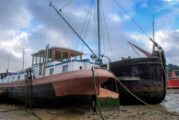 Boats stranded by low tide on the River Orwell at Pin Mill, Suffolk, UK