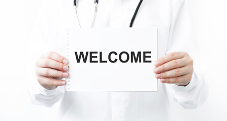 Doctor holding a card with text welcome, medical concept