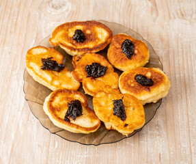 Pancakes or fritters with jam in plate on a table