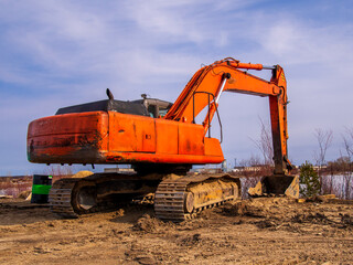 Powerful orange excavator in rural area