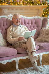 Grey-haired man reading a book and looking contented
