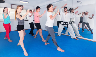 Young adult trainees practicing new maneuvers in a karate class