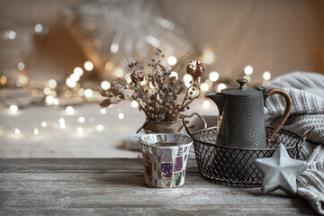 Cozy winter background with details of home decor on a blurred background with lights copy space.