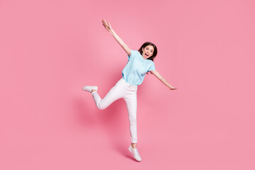 Fototapeta na wymiar Full size photo of cheerful girl jump hold hands fly bird concept isolated over pastel color background