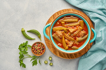 Homemade okra and meat stew in a pot. Top view, copy space
