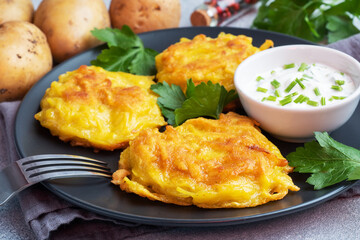 Fried cakes of grated potatoes on the plate with sauce. Traditional pancakes boxty raggmunk.