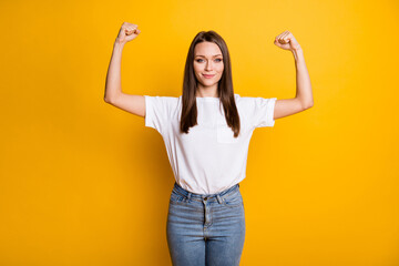 Photo portrait of fit girl showing muscles isolated on bright yellow colored background