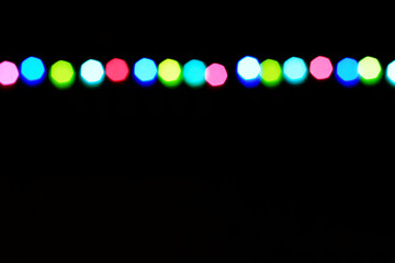 Festive background with a string of coloutful de-focused lights