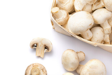 Fresh champignons in a basket isolated on white background.
