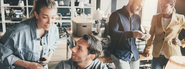 Business concept. Young team working together at the project in big open space office. Wide screen,...