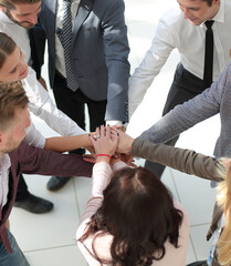 group of young business people putting their hands together.