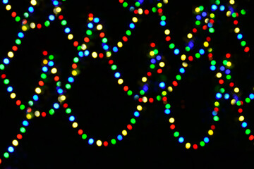Colourful Christmas garlands against black background.