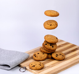 Oatmeal cookies with raisins fall on a wooden Board on a white background.